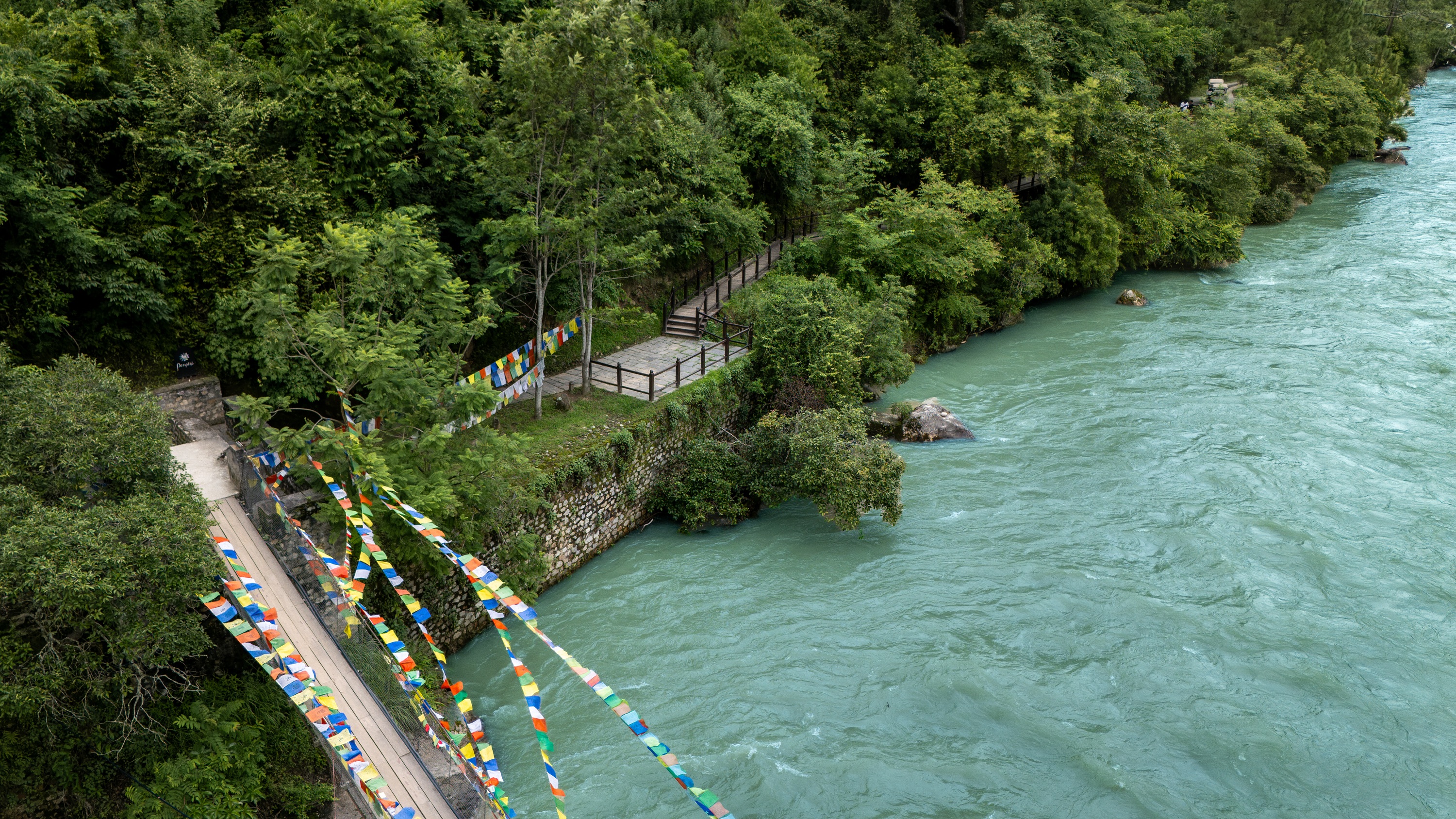River and prayer flag bridge at Pemako Punakha